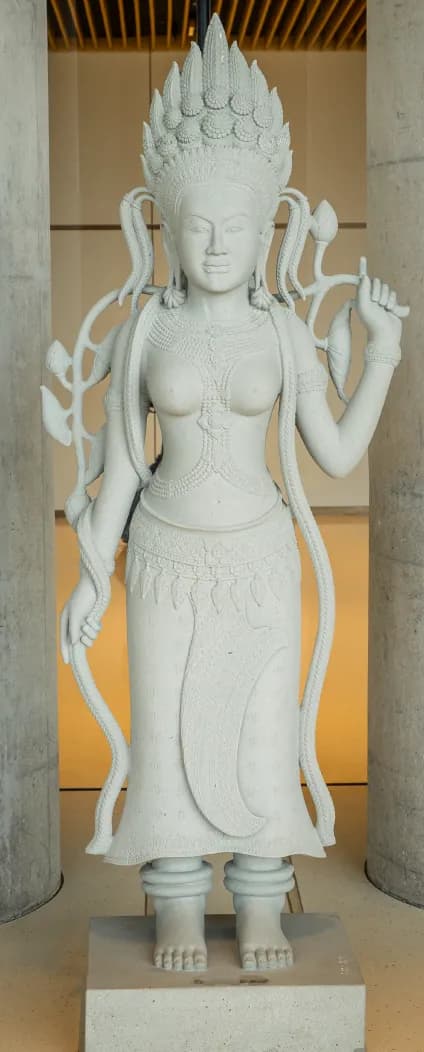 A stone statue of an apsara between two columns