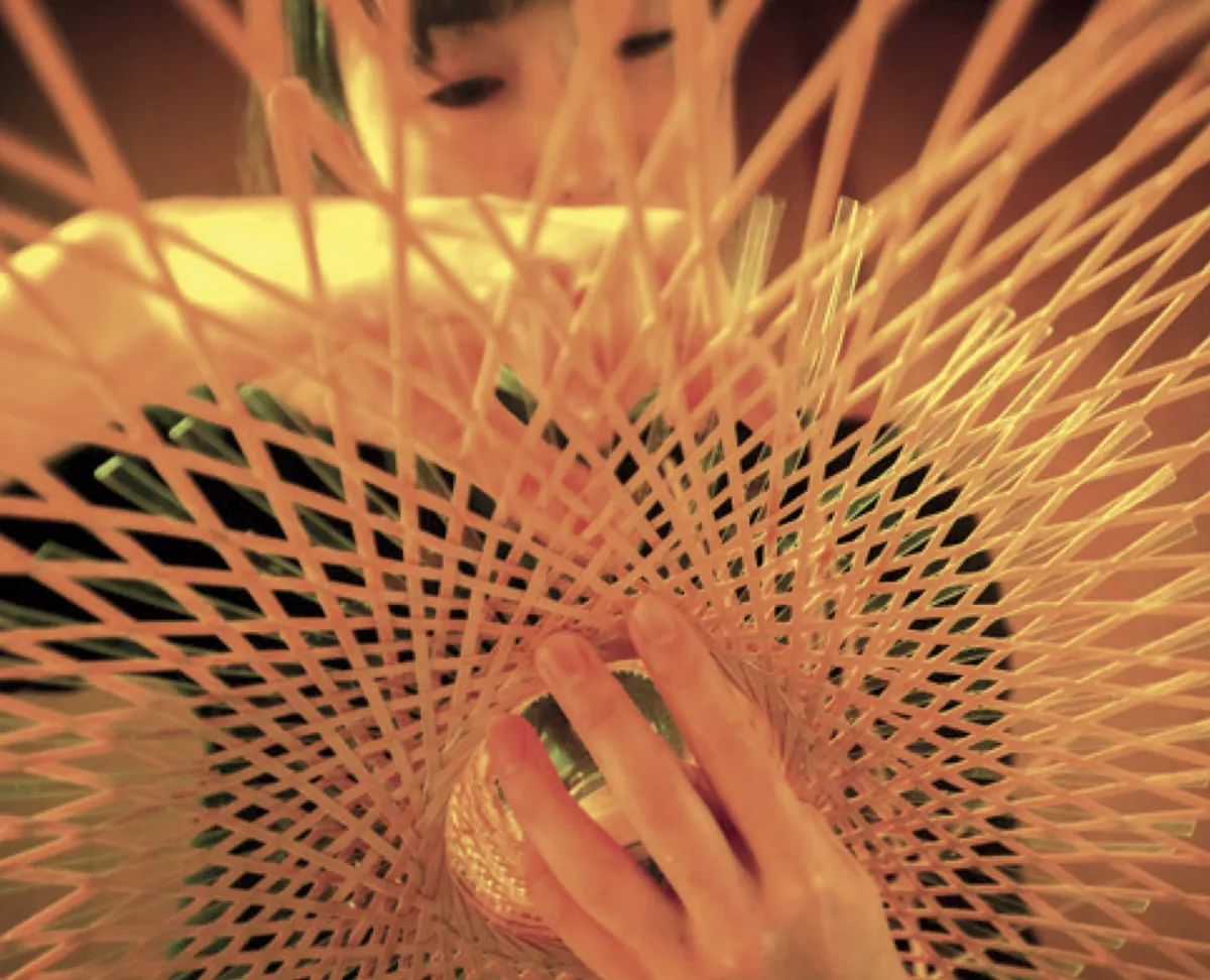 Hands weaving strips of bamboo
