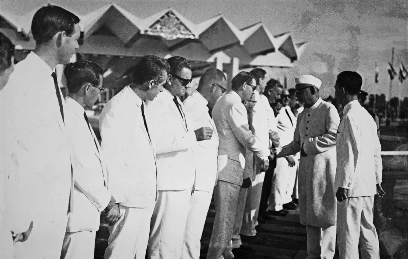 Officials dressed in white greeting guests at the airport