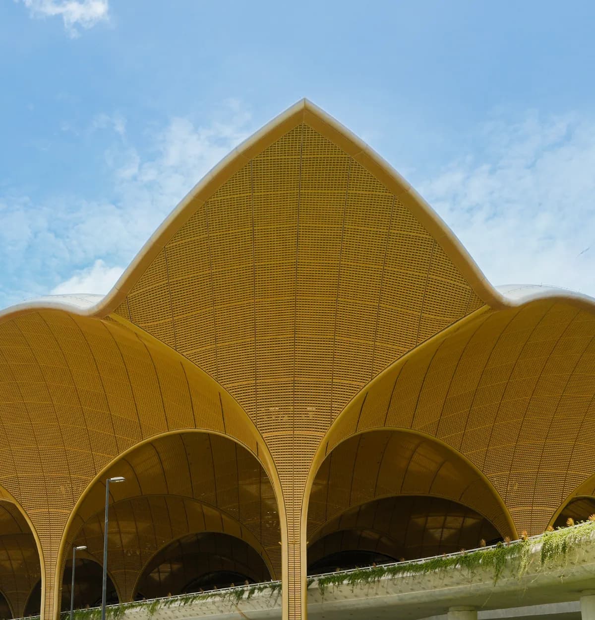 A roof rising in points like petals, above arches
